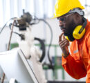 portrait-native-american-engineer-technician-wearing-safty-uniform-hand-contril-automation-robot-arm-welding-machine-with-laptop-industrial-40-factory-background-concept (FILEminimizer)